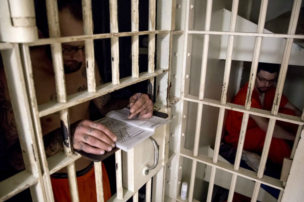 First Place, News Picture Story - Jessica Phelps / Newark Advocate, “Life Locked Up in the County Jail”Joel Davis works on a word search puzzle using the light available outside his cell in May 2020. There is a lack of funding for any sort of program including Alcoholics Anonymous  or bible studies at the jail. 